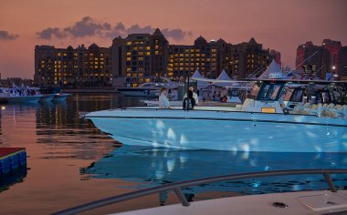 Porto Arabistan 'daki inci limanı, Doha, Katar gece görüşü önplanda yatlar, gökyüzünde binalar ve bulutlar