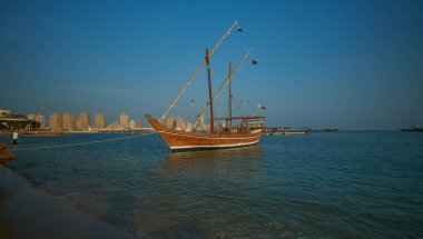 Katara 'da Doha Katar' da 11. geleneksel dhow festivali. Gün batımı çekimleri Katar Bayrağı ile Arap Körfezi 'nde yapılan duşları gösteriyor.
