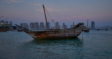 Katara 'da Doha Katar' da 11. geleneksel dhow festivali. Gün batımı çekimleri Katar Bayrağı ile Arap Körfezi 'nde yapılan duşları gösteriyor.