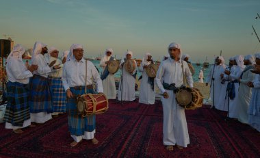 Katara 11. Geleneksel Dhow Festivali Doha Katar 'da geleneksel Katar folklor dansını gösteren gün batımı çekimleri (Ardah dansı) 