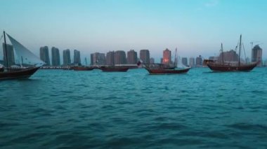 Katara 'nın Doha Katar' da 11. geleneksel yemek festivali. Günbatımında, arka planda Katar Bayrağı ve Katara ufuk çizgisini gösteren yelkenli tekneden çekiliyor.