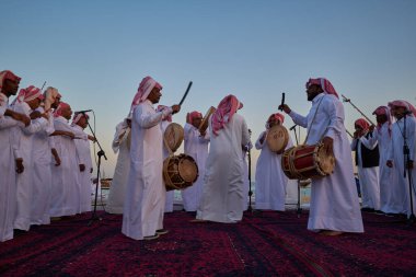 Katara 'da geleneksel Katara folklor dansı (Ardah dansı) Doha Katar' da 11. geleneksel dhow festivali günbatımı sahnesi  