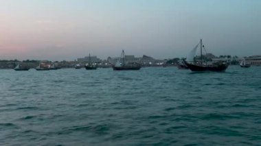 Katara 'nın Doha Katar' da 11. geleneksel yemek festivali. Günbatımında, arka planda Katar Bayrağı ve Katara ufuk çizgisini gösteren yelkenli tekneden çekiliyor.