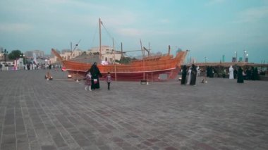 Doha Katar 'da düzenlenen 11. Geleneksel Dhow Festivali, Katar Bayrakları' nın yerel halk ve ziyaretçilerle sahile sergilendiği gün ışığını gösteriyor.