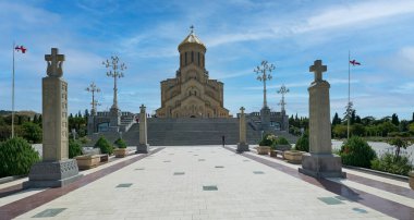 Kutsal Tiflis Trinity Katedrali, Gürcistan 'ın dış görünüşü katedralin eşsiz mimarisini gösteriyor. Merdivenlerde yürüyen insanlar ve gökyüzünde bulutlar var.   