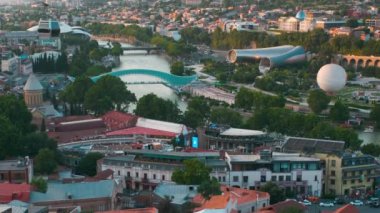 Tiflis, Gürcistan gün batımı Narikala kalesinin tepesinden manzara barış köprüsü, Rike Parkı, Kura Nehri ve Tiflis 'in Kutsal Üçlü Katedrali' ni gösteriyor.