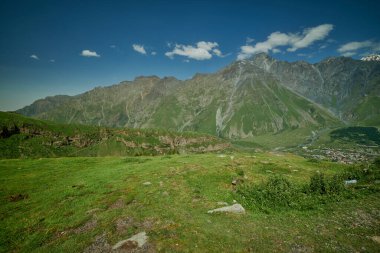 Mount Kazbek or Mount Kazbegi in Stepantsminda, Georgia daylight shot in summer  with clouds in the sky in background