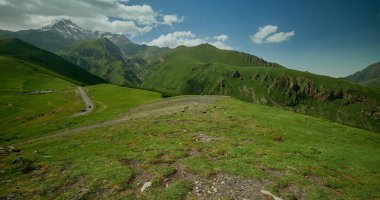 Mount Kazbek or Mount Kazbegi in Stepantsminda, Georgia daylight shot in summer  with clouds in the sky in background