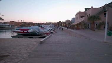 Ebu Tig Marina, El Gouna, Hurghada, Kızıldeniz Valiliği, Mısır 'da gün batımı manzarası turist yürüyüşleri ve lüks yatları gösteriyor.