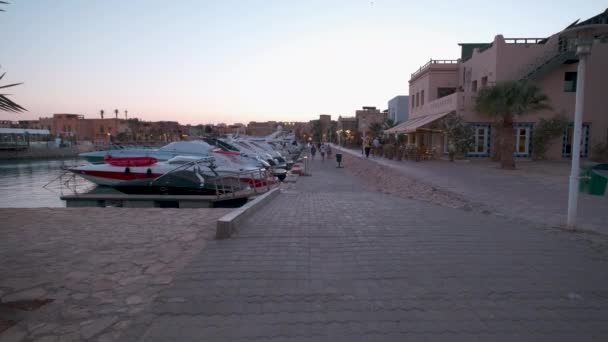 埃及红海省胡尔加达省El Gouna的Abu Tig Marina日落景观 显示游客步行和豪华游艇 — 图库视频影像