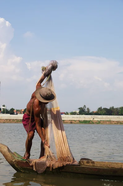 Pescador en una barcaza de madera con red de pesca en el río — Foto de Stock