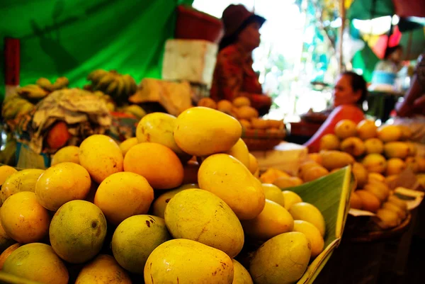 Montón de mangos frescos en un puesto de mercado, frutas tropicales Imagen de stock