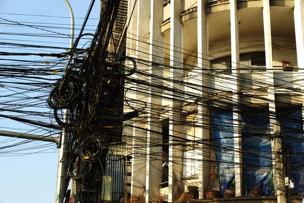 Muchos cables eléctricos frente a una fachada art deco en Asia —  Fotos de Stock