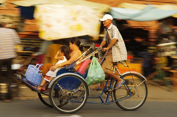 Rickshaw bicycle with passengers driving by, old man cycling — Stock Photo, Image