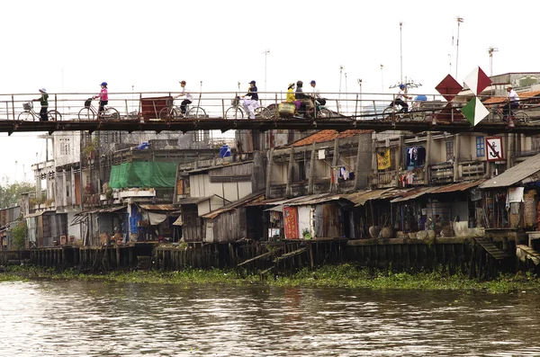 Mekong del nehir üzerinde bir köprüyü geçtikten bisiklet sürücüleri — Stok fotoğraf