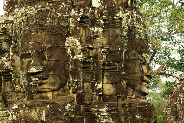 Rzeźbione kamienne twarze w starożytnej świątyni w angkor wat, Kambodża — Zdjęcie stockowe