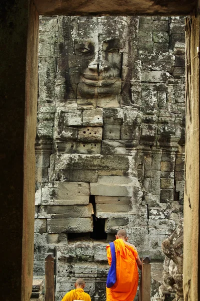 Buddhist monks in Angkor Wat, Cambodia, in front of a stone carv — Stock Photo, Image