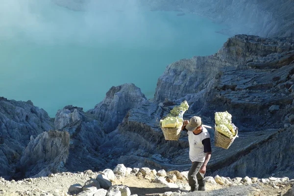 Trabajador minero de azufre en un volcán activo Imágenes de stock libres de derechos