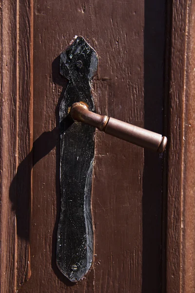 Oude deurklink van een houten deur — Stockfoto