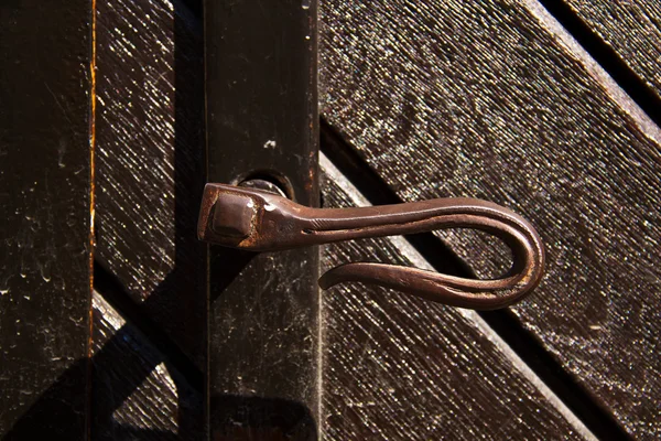 Oude deurklink van een houten deur — Stockfoto