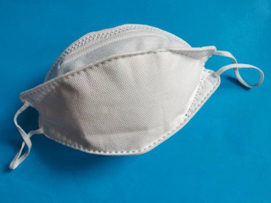 Mavi arka planda COVID-19 'a karşı korunmak için KN95 tıbbi maskesi, izole edilmiş