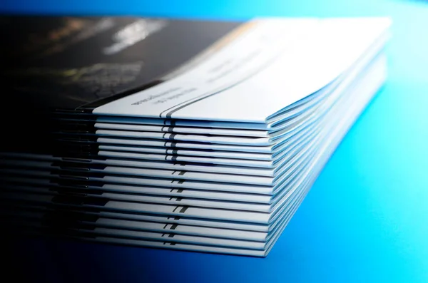 pile of annual report books on a blue background, isolated