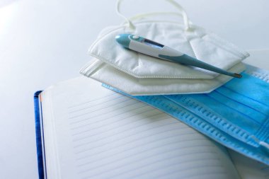 Tıbbi maske termometresi ve defter beyaz, izole