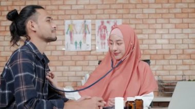 Genç, güzel kadın doktor, erkek hastayı hastane kliniğinde muayene ediyor ve ilaçlarla ilgili bir tebessümle danışmanlık yapıyor. Bu Asyalı tıp uzmanı tesettür takan bir İslamcı..