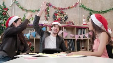 Kırmızı şapkalı üç işçi takımı, iş arkadaşları ve arkadaşları konuşuyor, merhaba beş ve şirket tatilinden önce dinlendirici toplantı, Noel partisi ve yeni yılı kutlamak için şenlik dekorasyonu.
