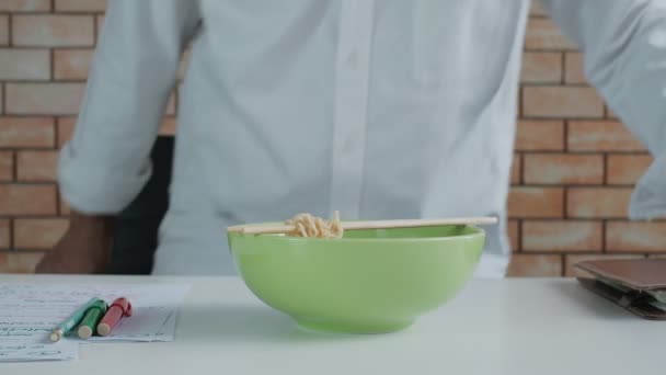 Azjatycki Mężczyzna Pracownik Czyta Książkę Spotkań Podczas Jedzenia Makaronu Instant — Wideo stockowe