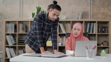 İslamcı olan iki genç girişimci, e-ticaret sektöründe gülümseyerek çalışmanın başarısından bahsediyor. Küçük bir ofiste internet üzerinden çevrimiçi iletişim kurmak için laptop kullan.
