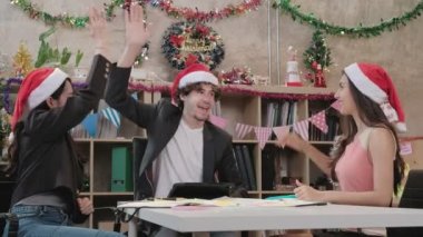 Kırmızı şapkalı üç işçi takımı, iş arkadaşları ve arkadaşları konuşuyor, merhaba beş ve şirket tatilinden önce dinlendirici toplantı, Noel partisi ve yeni yılı kutlamak için şenlik dekorasyonu.