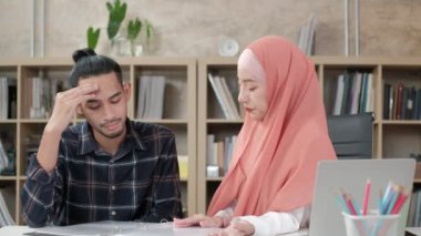 İslamcı olan iki genç girişimci, e-ticaret sektöründe gülümseyerek çalışmanın başarısından bahsediyor. Küçük bir ofiste internet üzerinden çevrimiçi iletişim kurmak için laptop kullan.