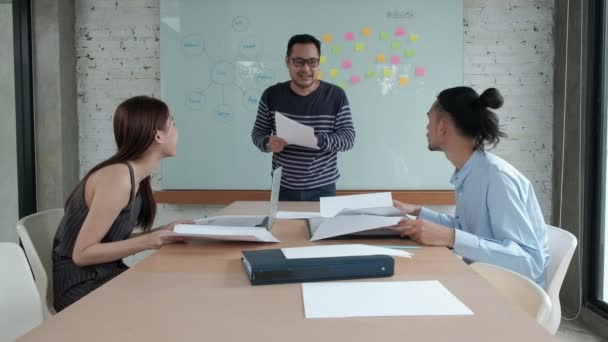 幸せなアジアのプロフェッショナルオフィスチームは陽気で 同社のビジネスの成功を祝います ボード上のカラフルな付箋で会議室を飛び回りました — ストック動画