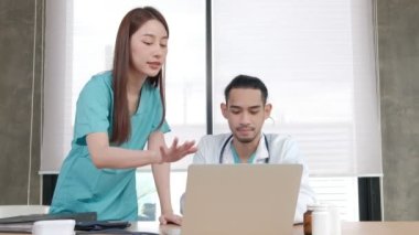 Sağlık ekibi ortakları. İki üniformalı genç Asyalı etnik köken doktoru hastane kliniğinde ilaçları tartışan iş arkadaşları. Uzmanlar uzman ve profesyoneldir..