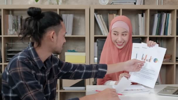 两名年轻的初创同事都是伊斯兰教徒 他们谈论着成功地在电子商务行业工作 面带微笑 在一个小办公室里用笔记本电脑通过因特网进行在线交流 — 图库视频影像