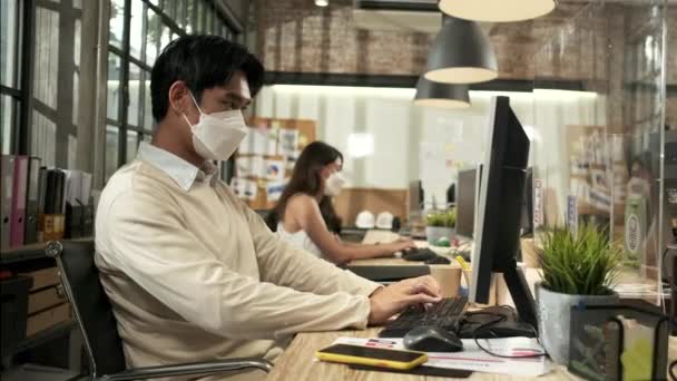 2人の同僚チームは 新しい通常のオフィスで働いてマスクの同僚に直面している Covid 19クリアパーティション 事業場オフィス パンデミック健康のための社会的距離 病気の予防による保護 — ストック動画