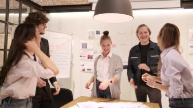 Happiness multiracial coworker's team celebrates business success and jobs done with the female Caucasian boss by fun dancing, cheerful when the meeting finishes in an office's conference workplace.