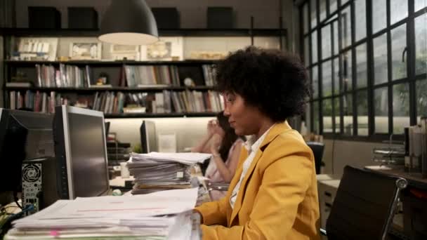 忙しい女性労働者 若いアフリカ系アメリカ人スタッフは 多くの書類や書類を机の上に積み上げ ビジネスオフィスのワークスペースでの仕事の締め切りのために精力的に働いています — ストック動画