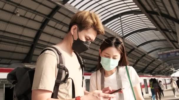 마스크를 아시아 관광객들은 휴대폰 지도를 장소를 찾는다 기차역 승객들의 일상적 — 비디오