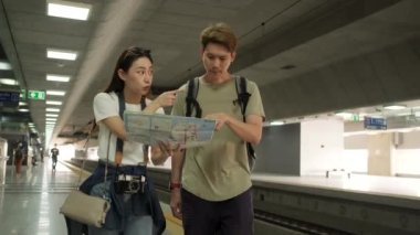 Harita ve kamera arama bilgilerine sahip genç Asyalı çiftler, konum buluyorlar, Tayland 'da tren istasyonunda seyahat ediyorlar, yolcu hayat tarzları, seyahatlerinde seyahat ediyorlar..