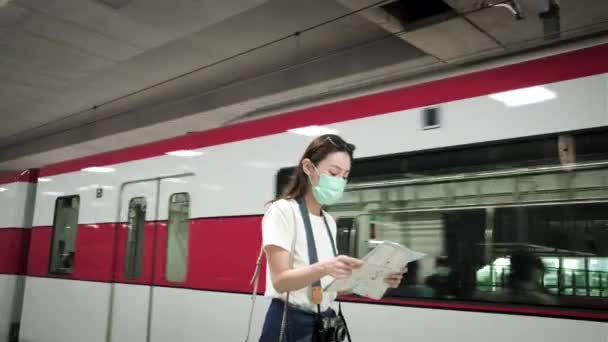 마스크 카메라를 아름다운 아시아 관광객 여행자의 기차역의 목적지찾기 — 비디오