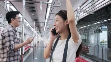 Boş gökyüzü treninde iki genç yolcu, kameralı bir turist ile güzel bir Asyalı kadın cep telefonuyla konuşuyor, Tayland şehir demiryolu taşımacılığıyla seyahat ediyor, mutlu bir yaşam tarzı tatili.