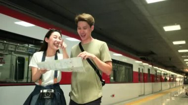 Taylandlı adam, güzel Asyalı bayanların turist arama bilgilerine yardım ediyor ve halka açık tren istasyonunda seyahat yeri, yolcu gezisi yaşam tarzı, seyahatte günlük ulaşım. 