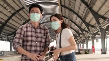 Yüz maskeli birkaç Asyalı turist arama bilgileri, Tayland 'daki bir tren istasyonunda cep telefonu haritasıyla seyahat yerleri, yolcu yaşam tarzı, günlük ulaşım, seyahat tatili. 