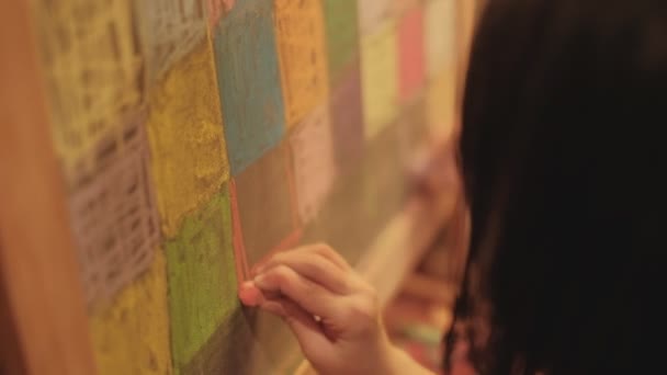 小女孩手工创作的特写镜头 用彩色粉笔 蓝色和幸福设计图解在孩子的闲暇教育的黑板上画艺术画 — 图库视频影像