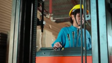 Endüstri fabrikasındaki kadın işçiler güvenlik üniforması ve hard hat ile depoyu dizüstü bilgisayarla teftiş ediyorlar, depoda stok siparişleri, karton istifleme kartonlarını forklift ile dolduruyorlar, ürün lojistik ürünleri üretiyorlar..