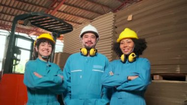 Üç çok ırklı güvenlik mühendisi kolları çaprazlanmış, gülümseyen ve birlikte gülen profesyonel teknisyen mukavva fabrikasıyla mutlu ve neşeli üç mühendis..