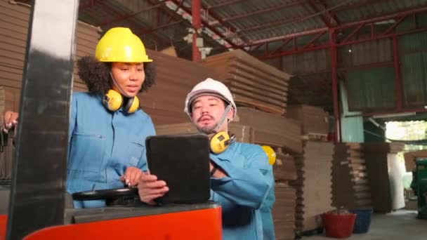 身穿安全制服 戴着硬礼帽的亚洲男性工程师和女工同事检查仓库 工厂仓库的库存订单 堆放成堆的硬纸板制造 工业产品管理 — 图库视频影像