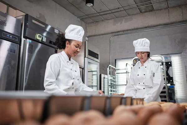 Dos Cocineras Profesionales Uniformes Blancos Delantales Amasan Masa Pastelería Huevos —  Fotos de Stock